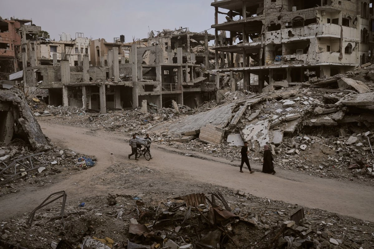 Palestinos caminan entre las ruinas de edificios destruidos en la ciudad de Gaza, el 24 de noviembre de 2025.