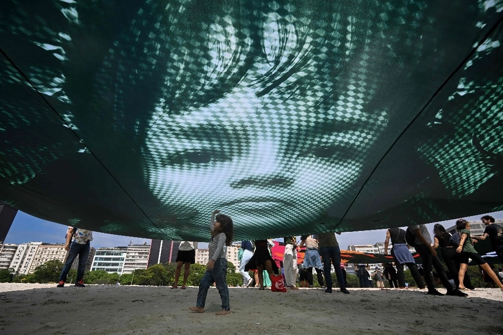 Manifestantes sostienen una imagen gigante del activista ambiental brasileño Txai Surui, para instar a los líderes del G20 a la protección del medio ambiente y la selva amazónica. Foto Afp