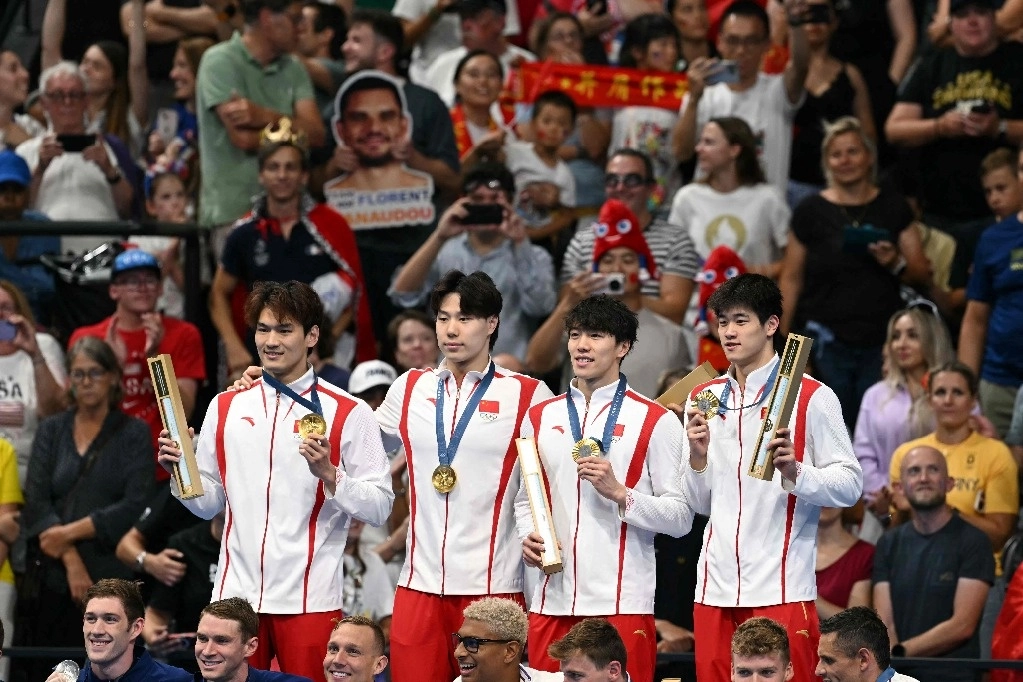 Los medallistas de oro del equipo China Xu Jiayu, Qin Haiyang, Sun Jiajun, y Pan Zhanle posan en el podio de la final masculina de natación con relevos combinados de 4x100 m durante los Juegos Olímpicos de París 2024 en el estadio París. Foto Afp
