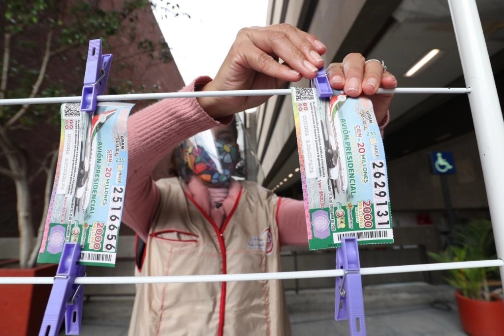 Una vendedora en un módulo de la Lotería Nacional con boletos para la rifa con motivo de la venta del avión presidencial en la explanada del Congreso de la Unión, el pasado 14 de septiembre. Foto Luis Castillo