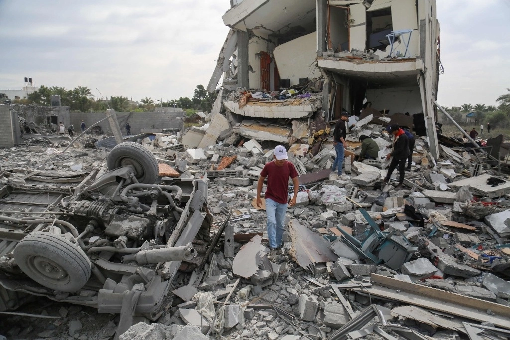 Palestinos buscan entre los escombros de la casa de la familia Tabatibi luego del bombardeo israelí nocturno al oeste del campo de refugiados de Nuseirat en Gaza. Foto Afp