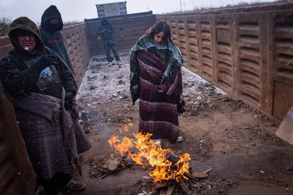 Los extranjeros llegan a la ciudad de Chihuahua a bordo del tren conocido como ‘La Bestia’, en medio de fuertes nevadas y bajas temperaturas. Para atenuar un poco el frío, encienden fogatas en los vagones donde viajan. Foto Cuartoscuro