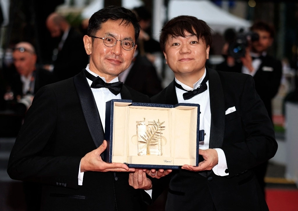 El vicepresidente de Eventos y Exhibiciones de Estudio Ghibli, Kenichi Yoda, y el director japonés  Goro Miyazaki, sostienen la Palma de Oro honorífica en Cannes. Foto Afp 