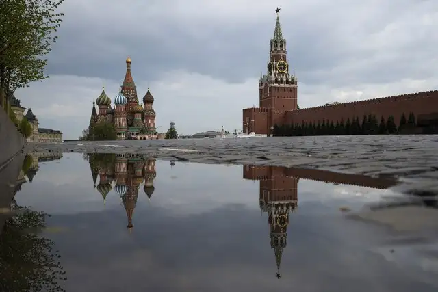 La Torre Spasskaya del Kremlin, al centro, y la Catedral de San Basilio reflejadas en el agua de lluvia en la Plaza Roja de Moscú. Foto Ap 