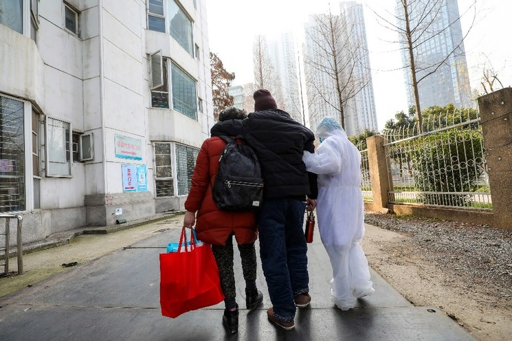 Personal de un hospital de la ciudad de Wuhan auxilia a un ciudadano. Foto Ap