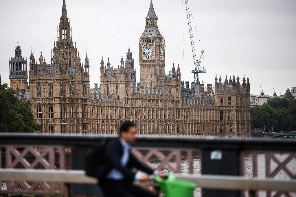 Una persona circula en bicicleta por el puente de Lambeth junto al río Támesis, con la Torre Eilizabeth, comúnmente conocida por el nombre de la campana del reloj ‘Big Ben’, en el Palacio de Wetsmintert, sede las Casas del Parlamento, al fondo, en el centro de Londres, el 2 de septiembre de 2024. Foto Afp 