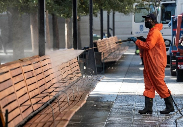 Un trabajador de Santiago en labores de limpieza de un parque. Foto Afp

