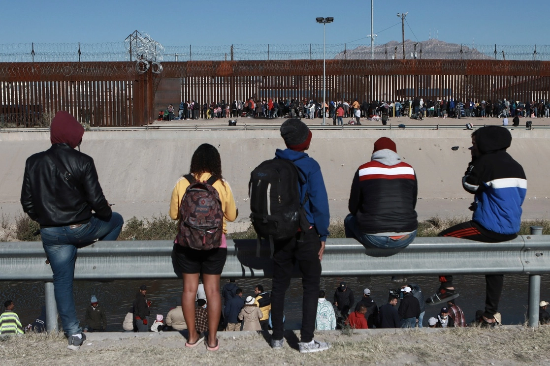Migrantes observan la valla fronteriza entre Ciudad Juárez y El Paso. Foto Ap.