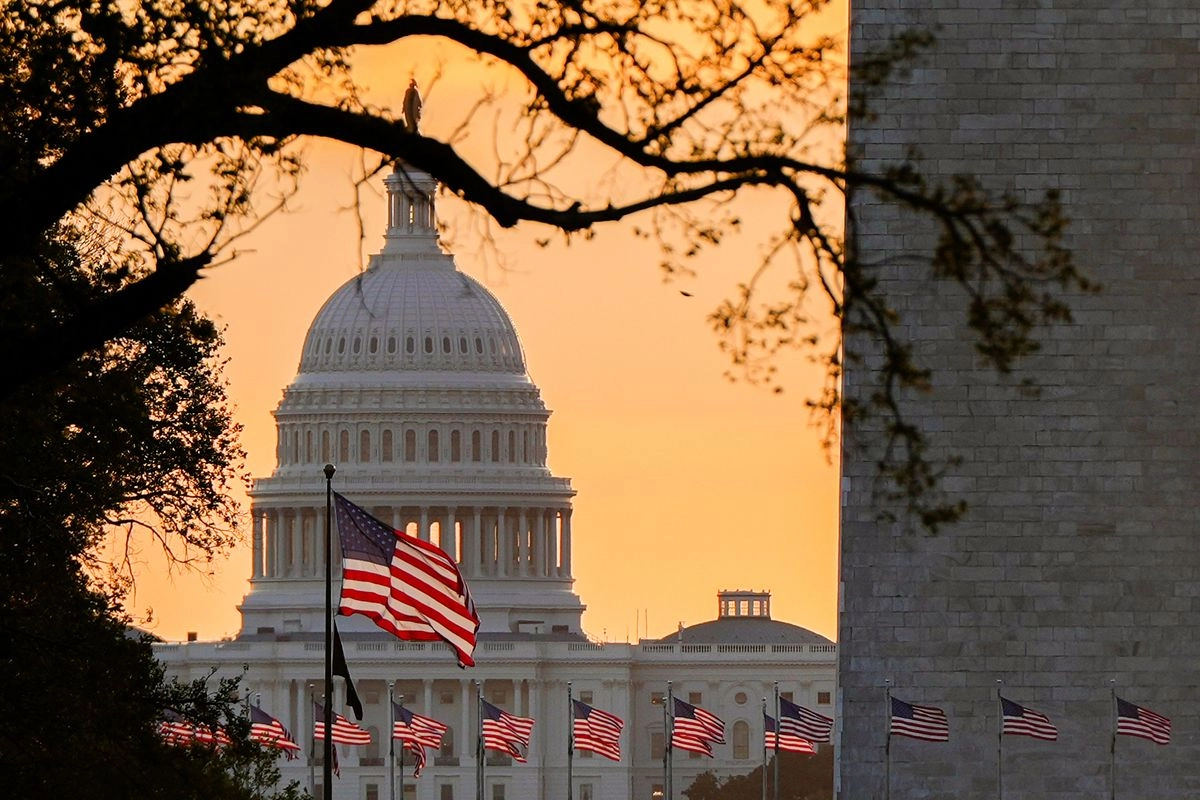 Banderas de EU ondean frente al Capitolio al amanecer en Washington, el 1° de octubre de 2025. Foto 