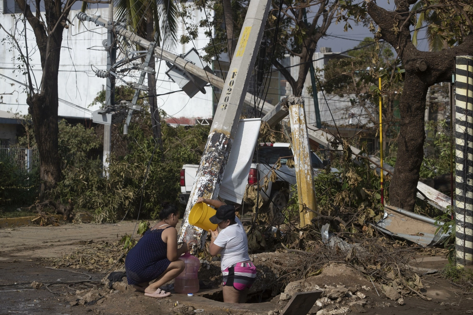 Residentes sacan agua de un registro ubicado en la colonia Progreso, en Acapulco, Guerrero, el 29 de octubre de 2023. Foto Alfredo Domínguez