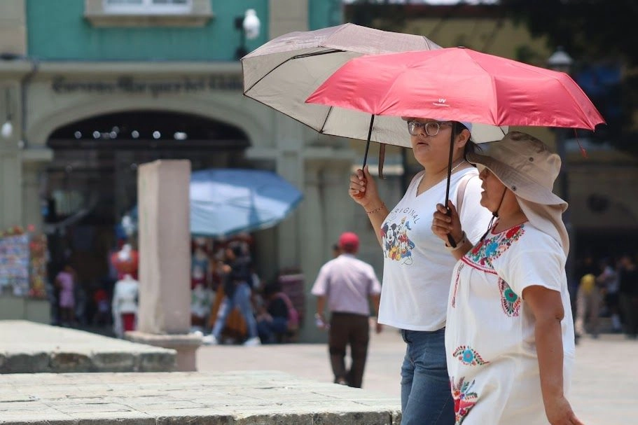 Habitantes de Oaxaca caminan por la alameda de la capital protegidas de los rayos del sol, ante las altas temperaturas ocasionadas por una onda de calor que golpea a la entidad. Foto 
