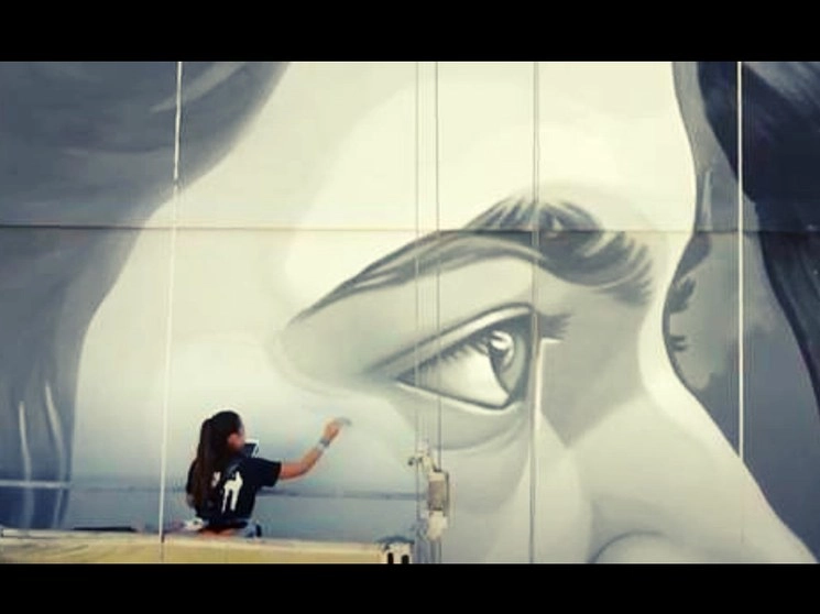 Paola Delfín (en captura de pantalla) participa en el Festival Internacional NaLata, que debió cancelar varias actividades, pero ver los murales desde la calle es algo democrático y no trae riesgos de aglomeración, explicó un organizador
