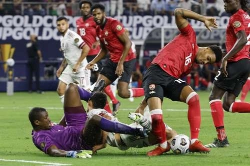 Tras recibir un fuerte empellón, la cabeza del 'Chucky' Lozano impactó en la rodilla del portero trinitario Marvin Phillip el sábado en Arlington. Foto Ap