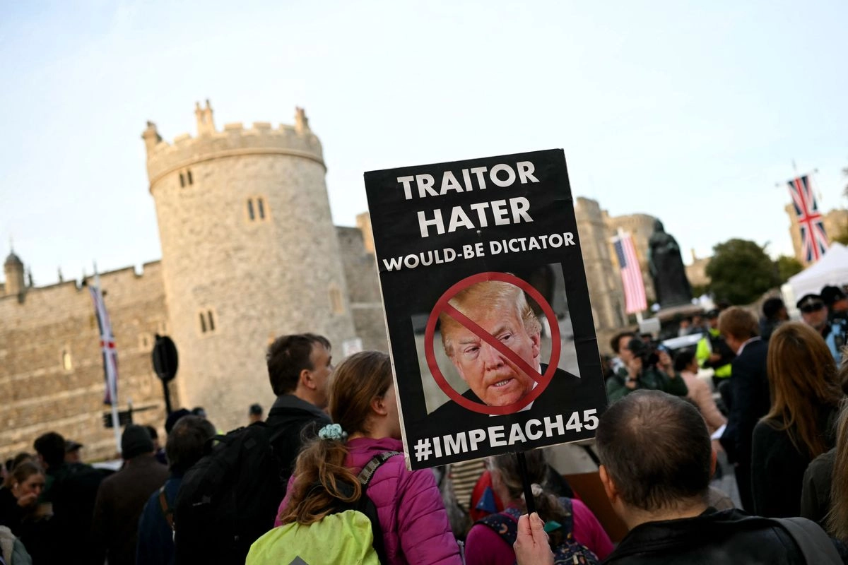 Un manifestante sostiene una pancarta durante una protesta contra la próxima visita de Estado del presidente estadunidense Donald Trump, frente al Castillo de Windsor, el 16 de septiembre de 2025. Foto