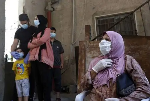 Palestinos aguardan a que trabajadores médicos recolecten las muestras para detectar el Covid-19. El gobierno utiliza unidades móviles para realizar pruebas en los campamento de refugiados de Al-Azza, en la ciudad cisjordana de Belén. Foto Ap