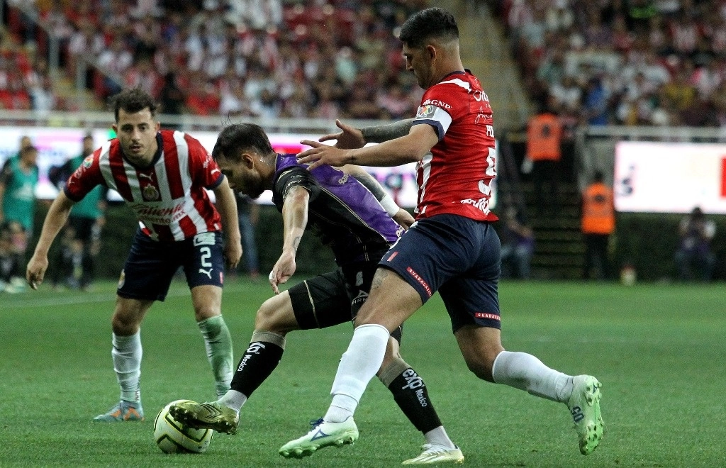 Víctor Guzmán (R) de Guadalajara compite por el balón con David Colman (L) de Mazatlán, durante su partido de fútbol del Torneo Clausura Mexicano, en el estadio Akron, en Guadalajara, Estado de Jalisco, México, el 29 de abril de 2023. Foto Afp