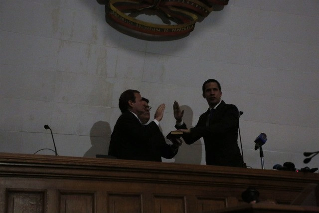 El líder opositor venezolano Juan Guaidó jura el cargo de presidente de la Asamblea Nacional, en una sesión sin luz eléctrica. Foto Ap