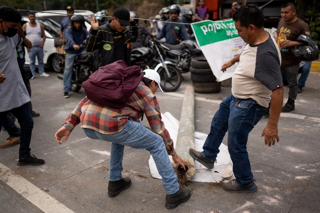 La gente bloquea la Carretera Interamericana en San Lucas Sacatepéquez, Guatemala, el viernes 13 de octubre. Foto Ap