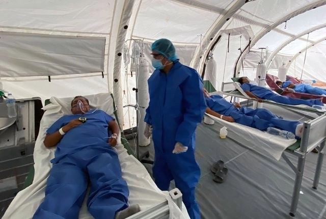 Un doctor revisa a un paciente con coronavirus en el hospital de Los Ceibos, en Guayaquil, Ecuador. Foto Afp 
