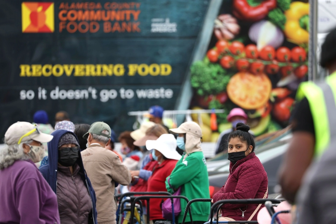 La gente espera en fila para recibir paquetes del Banco de Alimentos de la Comunidad del Condado de Alameda en California. Foto Afp