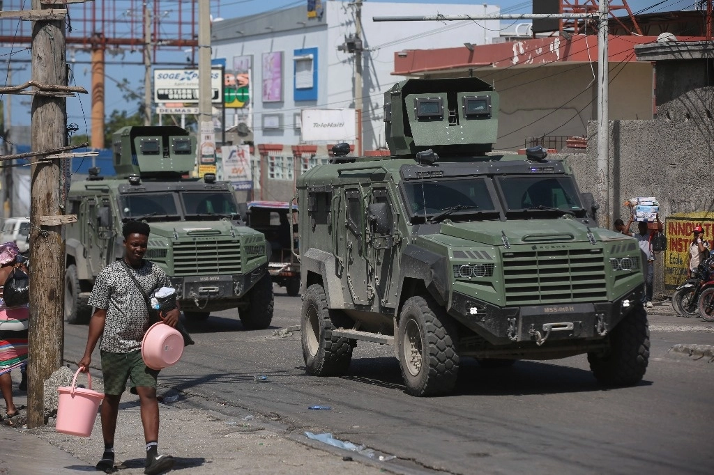 Vehículos de la policía de Kenia patrullan mientras los residentes huyen de sus hogares para escapar de la violencia de las pandillas en el barrio Delmas de Puerto Príncipe, Haití, el martes 25 de febrero de 2025. Foto Ap