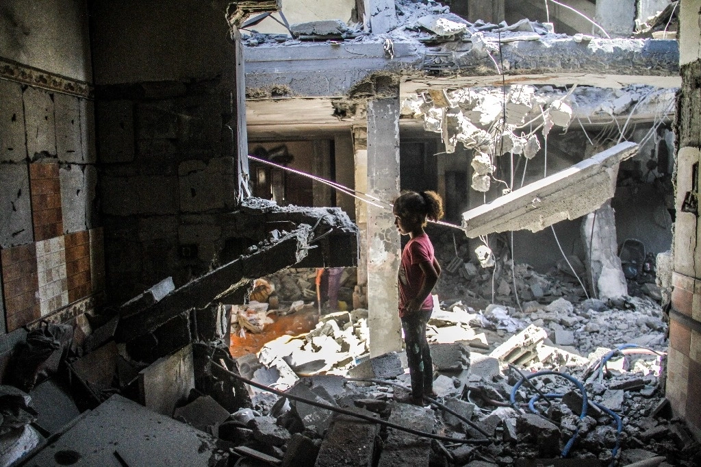 Una niña en medio de un edificio destruido por bombardeos israelíes en campamento de refugiados de Jabalia, al norte de la franja de Gaza. Foto Xinhua 