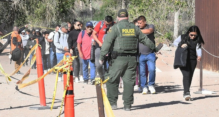 Policías fronterizos agrupan a migrantes que serán deportados. Foto Ap