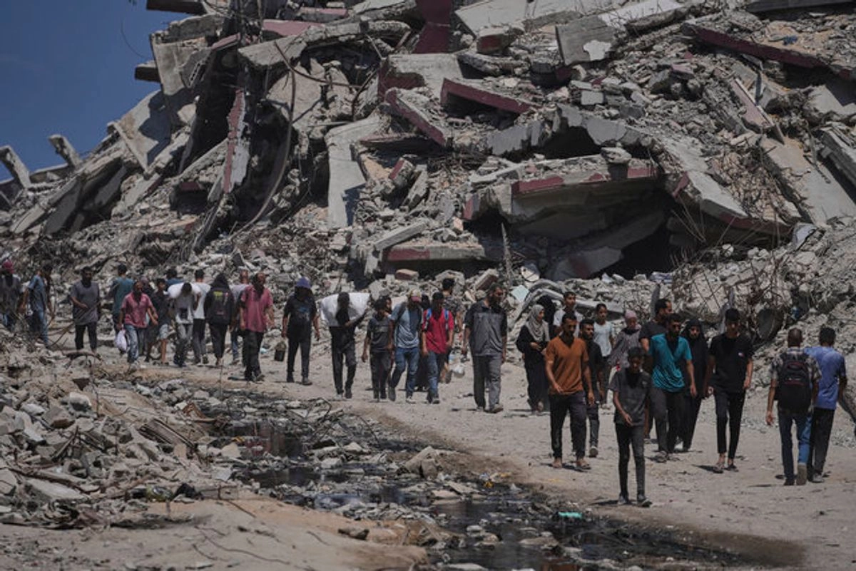 Palestinos cargan sacos de ayuda humanitaria descargados de un convoy de camiones que se dirigía a la ciudad de Gaza. Foto 