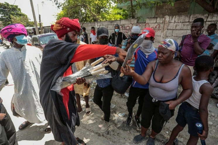 Nertil Marcelin, líder de una guardia comunitaria, distribuye machetes entre los habitantes de su barrio para hacer frente a las pandillas que buscan hacerse del control de la capital haitiana, Puerto Príncipe. Foto Ap.