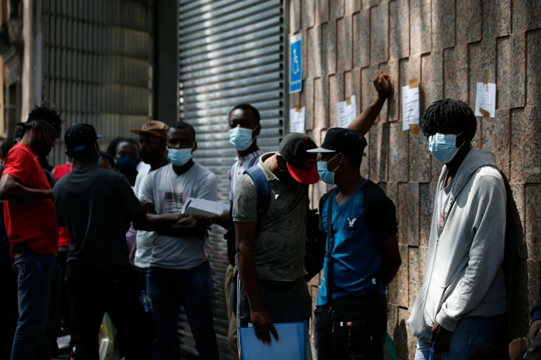 Haitianos esperan afuera de las instalaciones de la Comisión Mexicana de Ayuda a Refugiados (Comar) en la Ciudad de México para tramitar solicitudes de asilo, así como permisos de trabajo o de tránsito. Foto Alfredo Domínguez