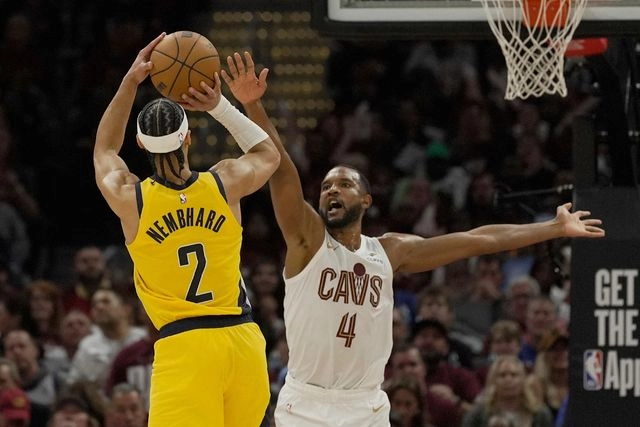 El base de los Indiana Pacers, Andrew Nembhard (2), lanza mientras el alero de los Cleveland Cavaliers, Evan Mobley (4), defiende. Foto 