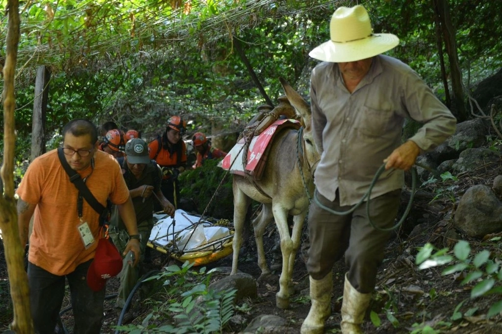 Elementos de protección civil de Tepetlán, así como de los municipios vecinos de Naolinco y Alto Lucero, en Veracruz, y habitantes de los poblados cercanos al río Seco, durante las labores de rescate de uno de los cuatro oficiales que fueron arrastrados por el cauce el viernes pasado. Foto Carlos Nava 
