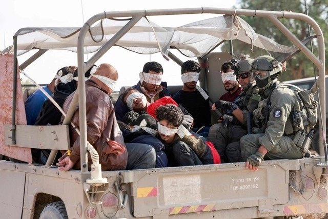 Soldados israelíes trasladan a palestinos detenidos fuera de la Franja de Gaza. Foto Afp