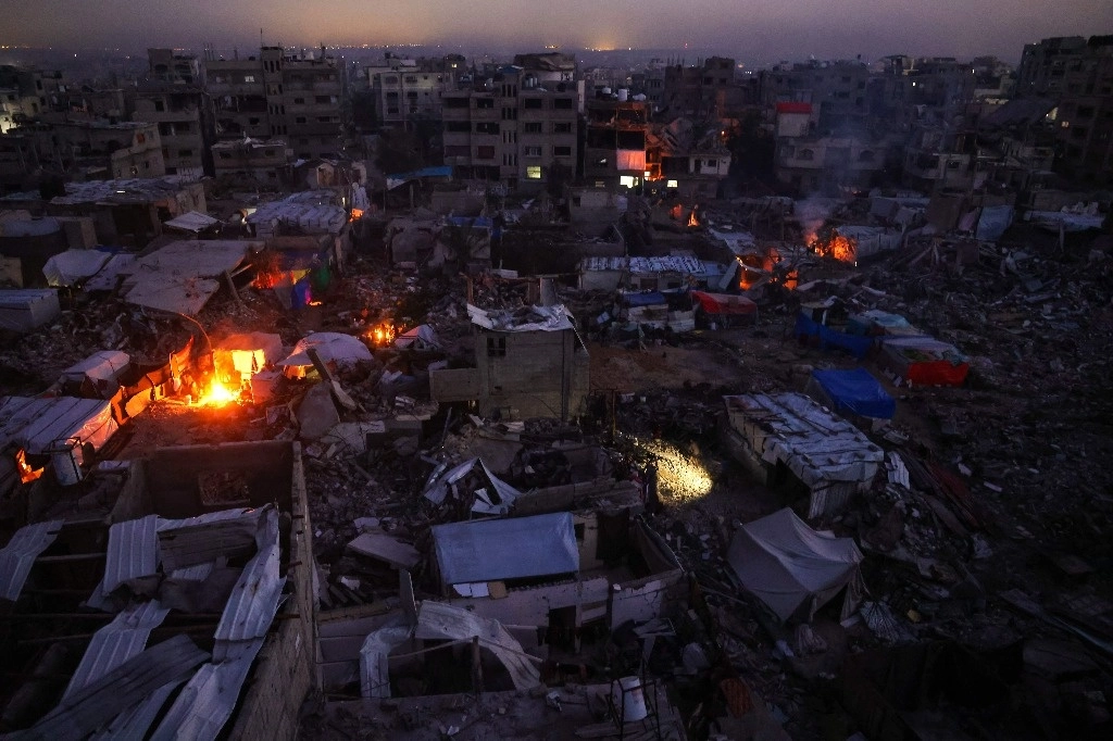 Palestinos acampan entre las ruinas de sus casas en Jabalia, en el norte de la Franja de Gaza, el 17 de febrero de 2025, mientras la gente regresa a las zonas del norte de Gaza durante el actual acuerdo de alto el fuego en la guerra entre Israel y Hamás. El primer ministro israelí, Benjamin Netanyahu, dijo el 17 de febrero que estaba "comprometido" con el plan del presidente estadounidense Donald Trump para Gaza, que implica desplazar a más de dos millones de habitantes del territorio palestino. Foto Afp