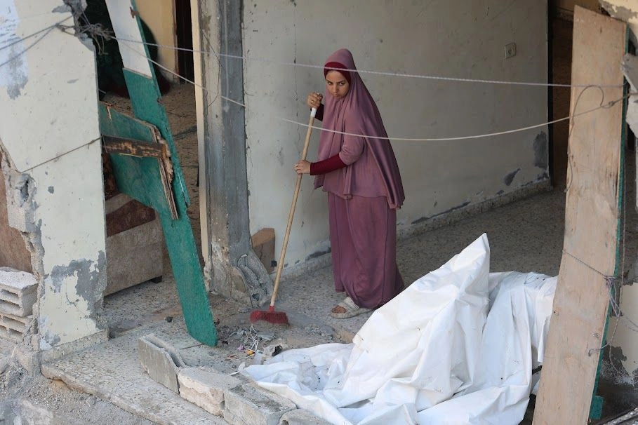 Una mujer palestina barre escombros después de un ataque israelí contra el campo de refugiados de Al-Shati, en el oeste de Gaza. Foto 