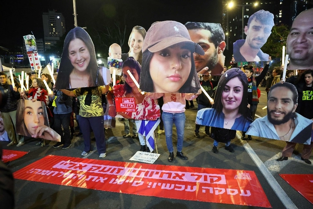 Manifestantes sostienen fotografías de rehenes israelíes que permanecen cautivos en Gaza, en Tel Aviv, Israel, el 4 de enero de2025. Foto Afp