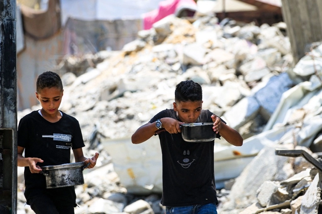 El campamento en Nuseirat, en el centro de la franja de Gaza, distribuye comida donada entre los desplazados. Foto Afp 
