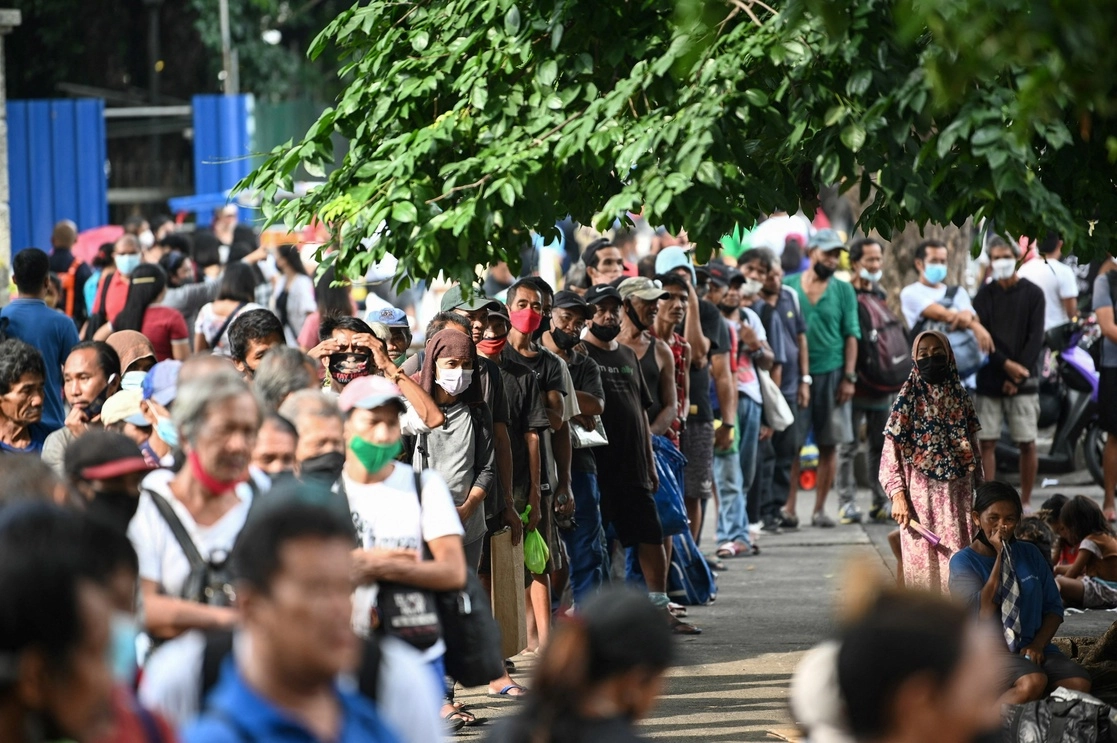Personas en Filipinas haciendo fila para recibir comida. Foto Afp