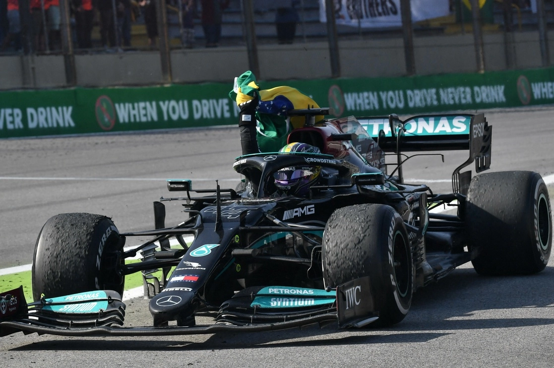 Lewis Hamilton sostiene la bandera de Brasil luego de ganar el GP en el autódromo José Carlos Pace en Sao Paulo. Foto Afp