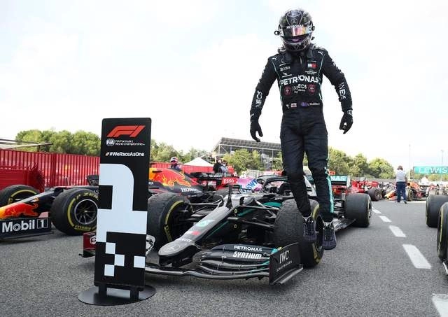 Lewis Hamilton desciende su monoplaza luego de ganar el GP de España. Foto Afp
