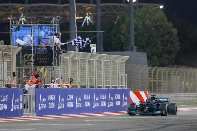 Lewis Hamilton recibe la bandera a cuadros tras llegar en primer lugar en el inicio de la temporada 2021 de la F1. Foto Afp