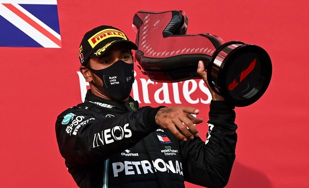 El piloto británicco Lewis Hamilton, de Mercedes, celebra con su trofeo en el podium su triunfo en el Gran Premio Emilia-Romaña en Imola, Italia, el 1 de noviembre de 2020. Foto Afp