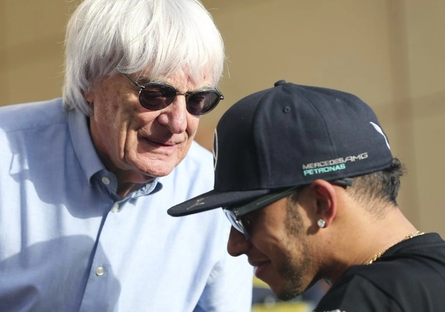 En imagen de 2015, Bernie Ecclestone habla con el piloto Lewis Hamilton. Foto Ap