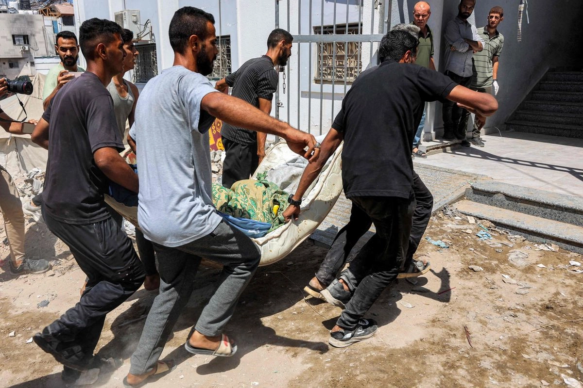 Hombres cargan el cuerpo de una víctima que murió durante un bombardeo israelí contra un campamento de desplazados, en el Hospital Shifa de la ciudad de Gaza, el 4 de septiembre de 2025. Foto 