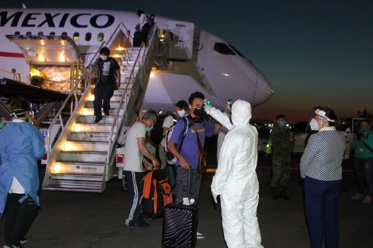 Toma de temperatura a mexicanos que regresaban al país en el contexto de la pandemia de Covid-19. Foto tomada del Twitter de @SRE_mx