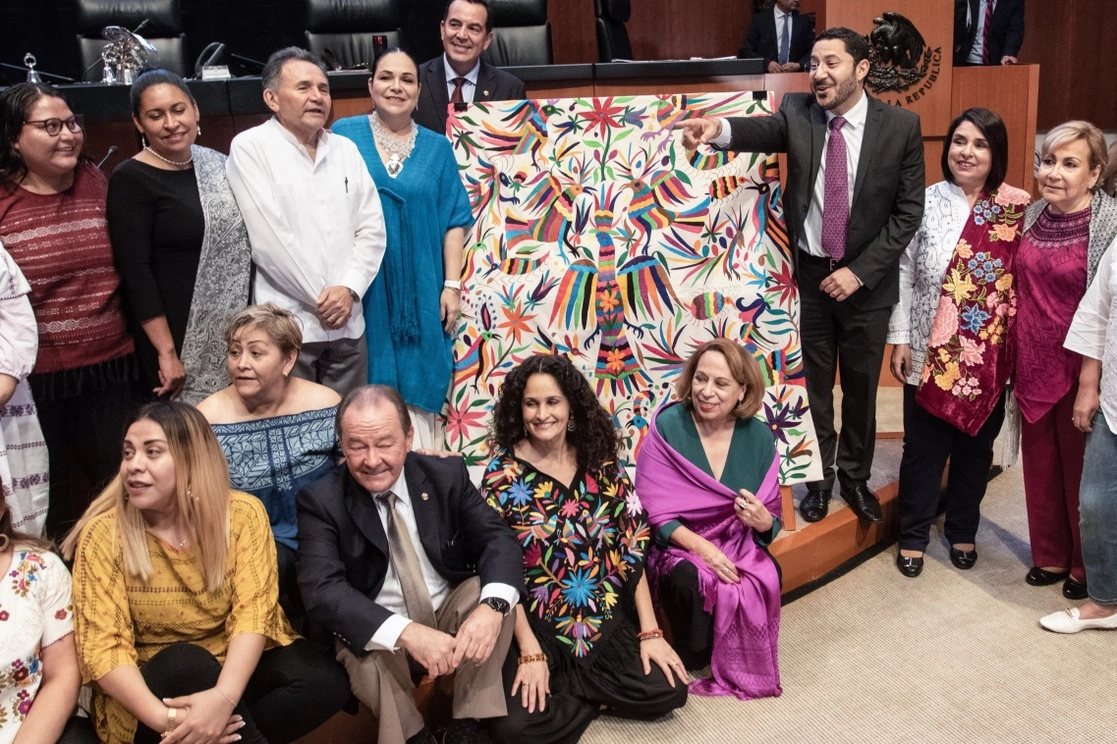La reforma permite a las comunidades afectadas presentar denuncias ante la FGR y entablar juicios para lograr una indemnización. En la imagen de junio de 2019, senadores de Morena posan junto a un bordado de Tenango de Doria, Hidalgo, tras la controversia por apropiación en contra de la marca Carolina Herrera. Foto Cuartoscuro