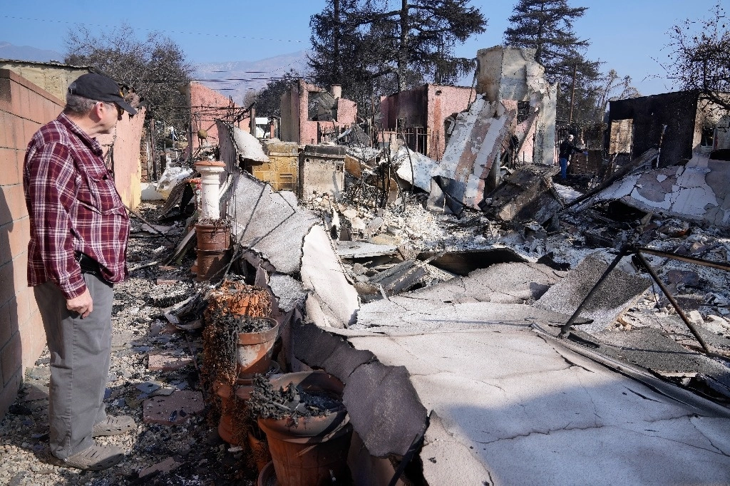 Un damnificado regresa al sitio donde se encontraba su casa y que resultó totalmente afectada por los incendios de Los Ángeles California. Foto AP  