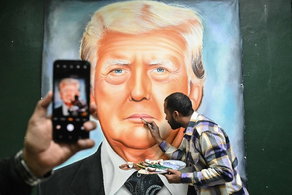 Un artista da los toques finales a una pintura del presidente electo de Estados Unidos, Donald Trump, en Amritsar, en el estado indio de Punjab, el 19 de enero de 2025. Foto Afp