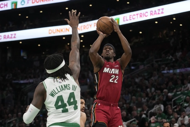 El jugador del Miami Heat, Jimmy Butler (c,der) realiza un tiro ante el jugador de Boston Celtics, Robert Williams III (c,izq). Foto Ap 
