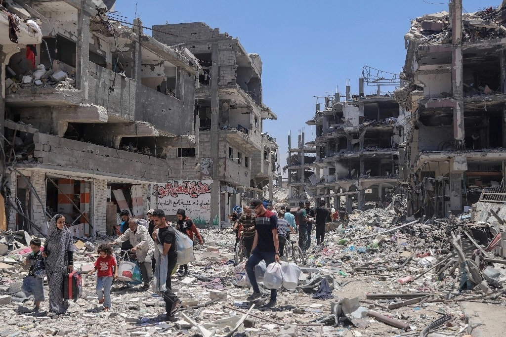 Palestinos caminan entre la destrucción tras una ofensiva aérea y terrestre israelí en Jebaliya, al norte de la Franja de Gaza. Foto Ap 